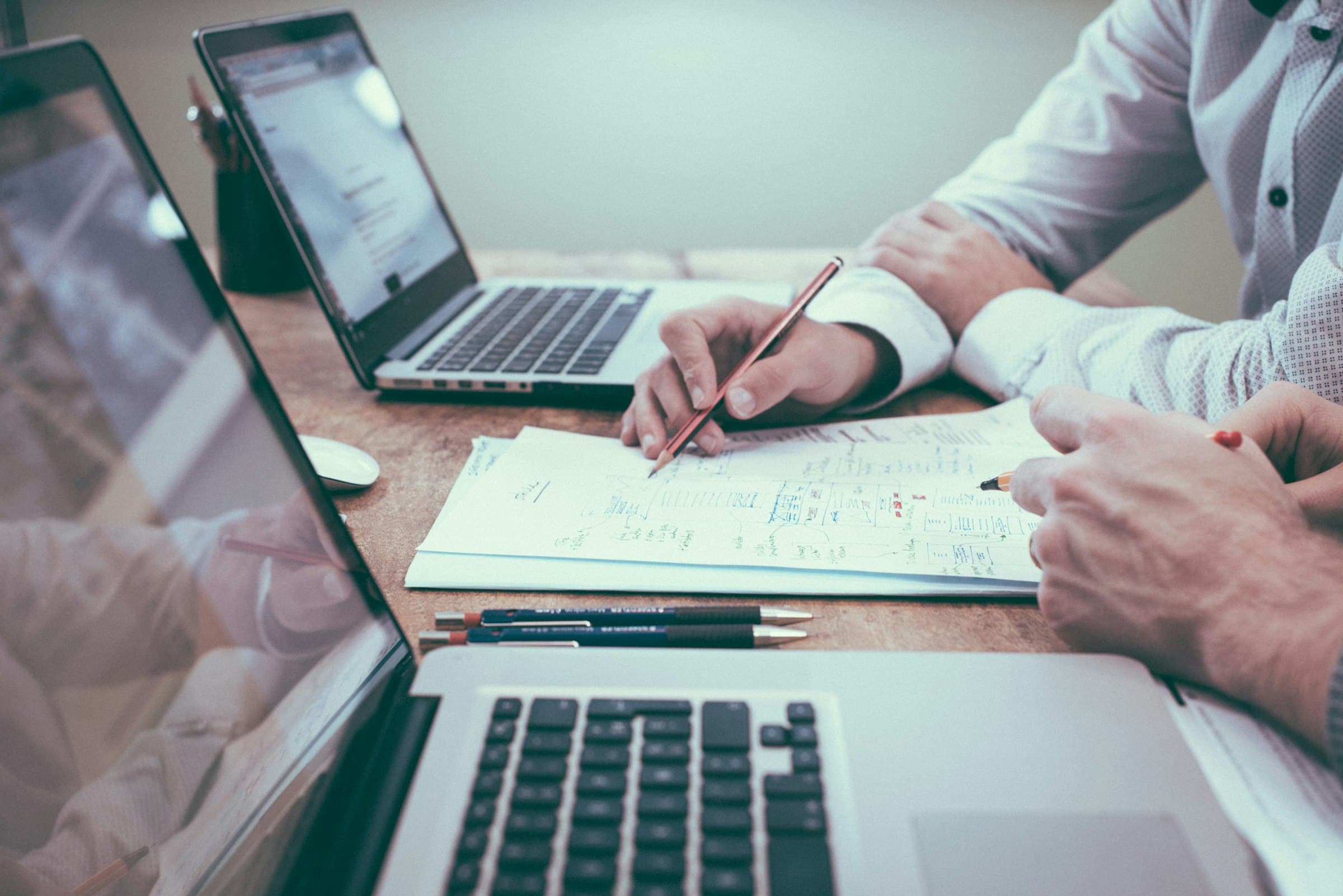 Professional reviewing documents with a calculator on a desk