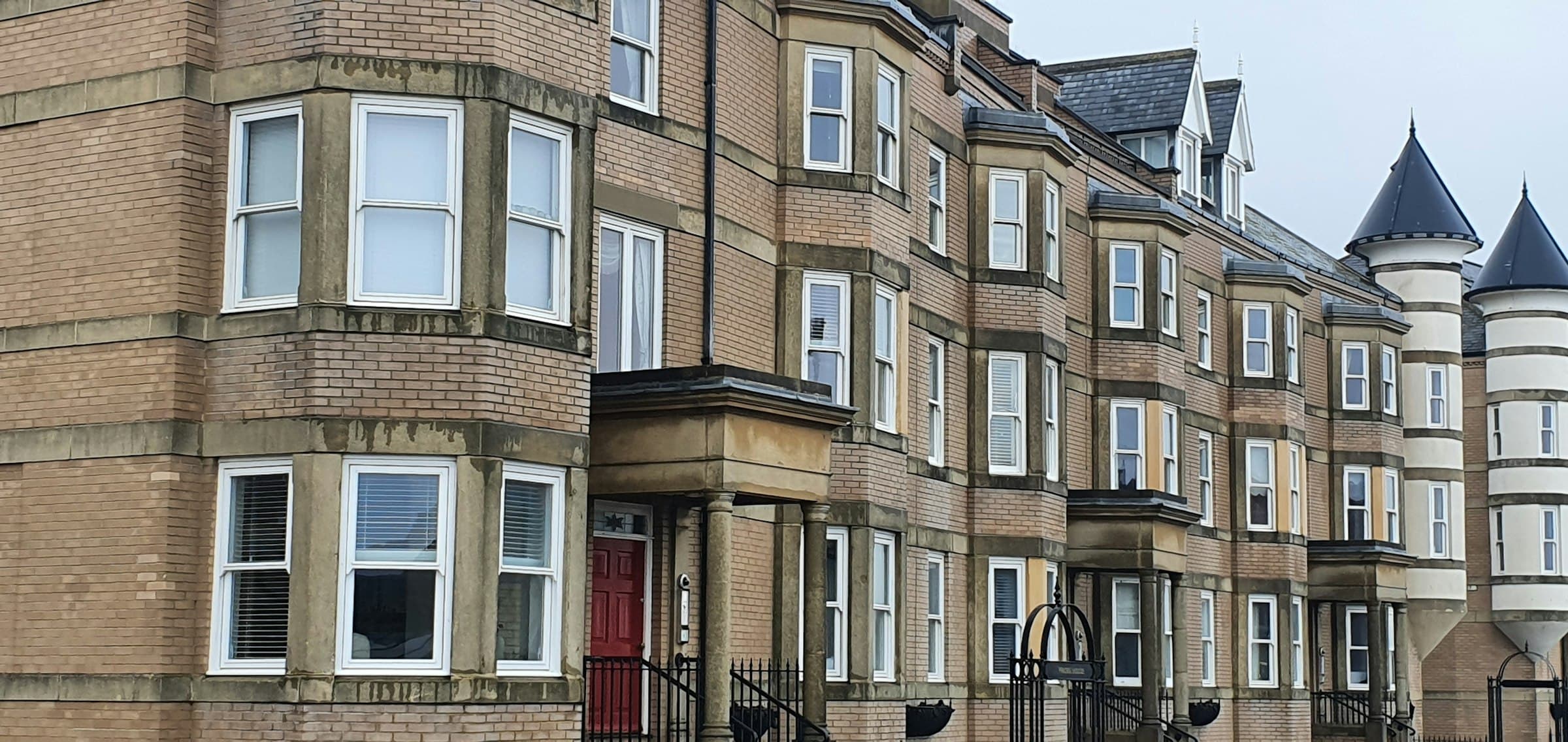 Row of historic red-brick terraced houses on a UK street